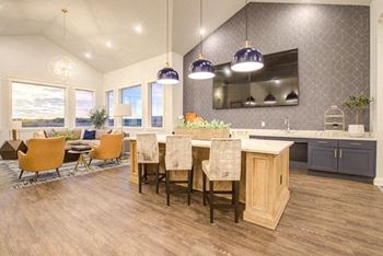 Clubhouse kitchen with a large center island with a bar at Connect at First Creek, Denver, Colorado